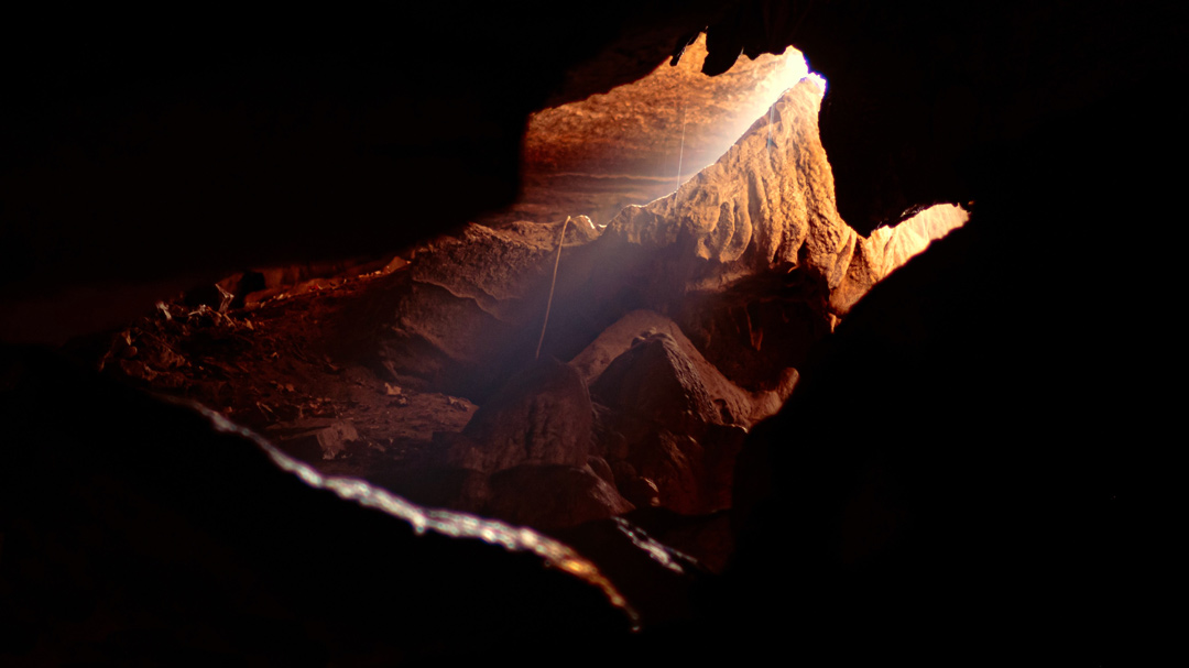 image of a cave being explored lit with headlights